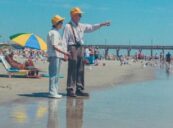 På bildet vises to eldre personer, antagelig pensjonister, som nyter en solrik dag på stranden