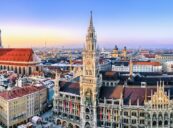 På bildet er det avbildet München med sin historiske arkitektur og moderne skyline ved solnedgang, en ideell scene for de som vurderer å flytte til München.